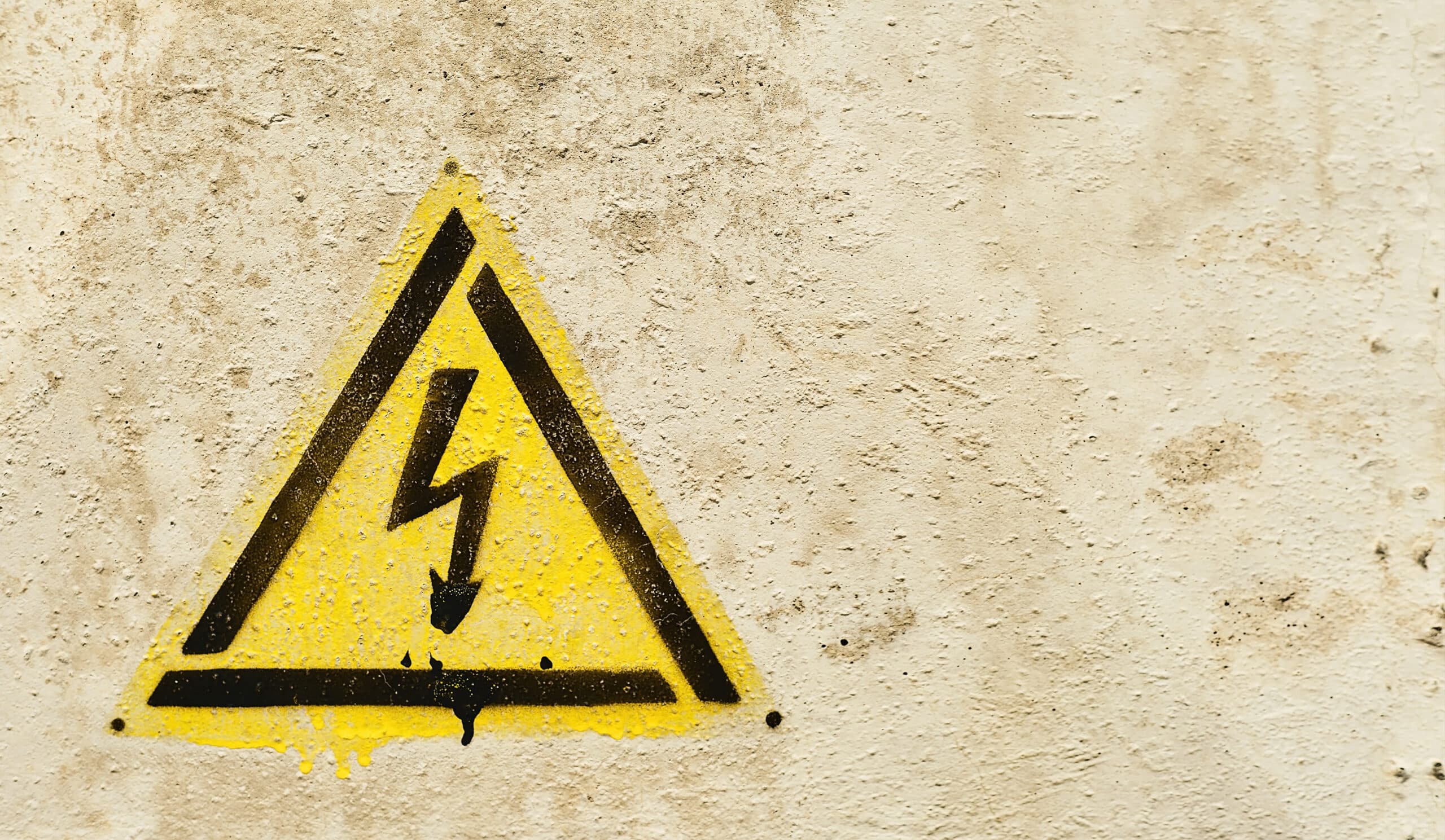 Danger sign of high voltage electricity. Yellow triangle hazard
