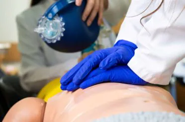 Medical Students practicing emergency cardiopulmonary resuscitation on a medical practice doll for emergencies